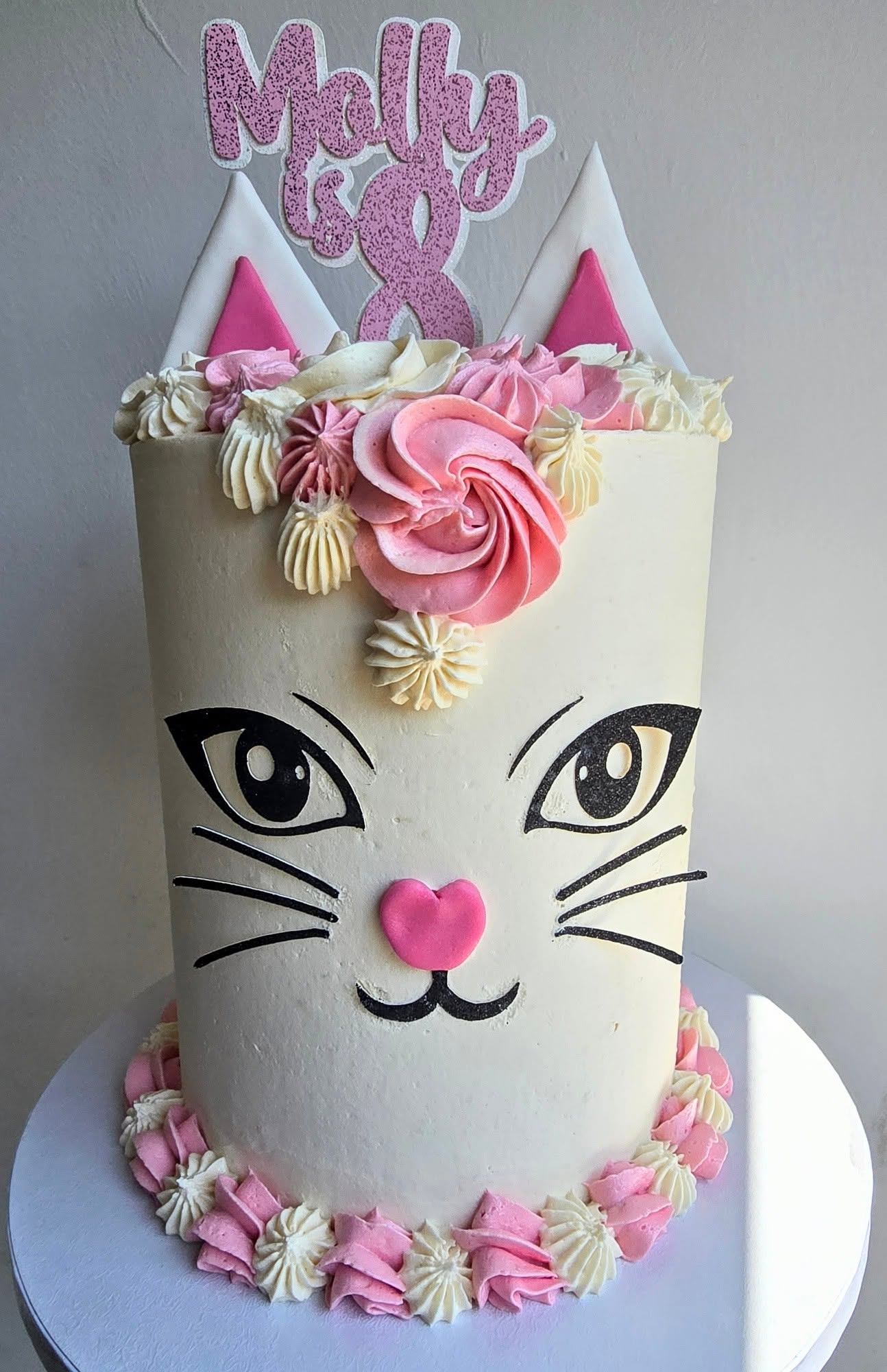A playful cat cake with pastel flowers and plenty of character.