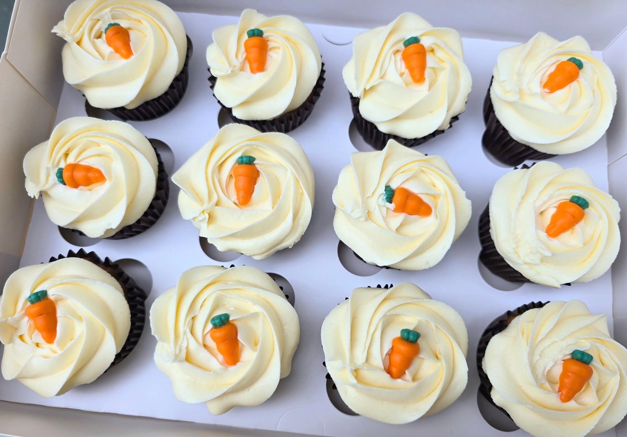 Pale buttercream swirls with miniature carrot decorations.